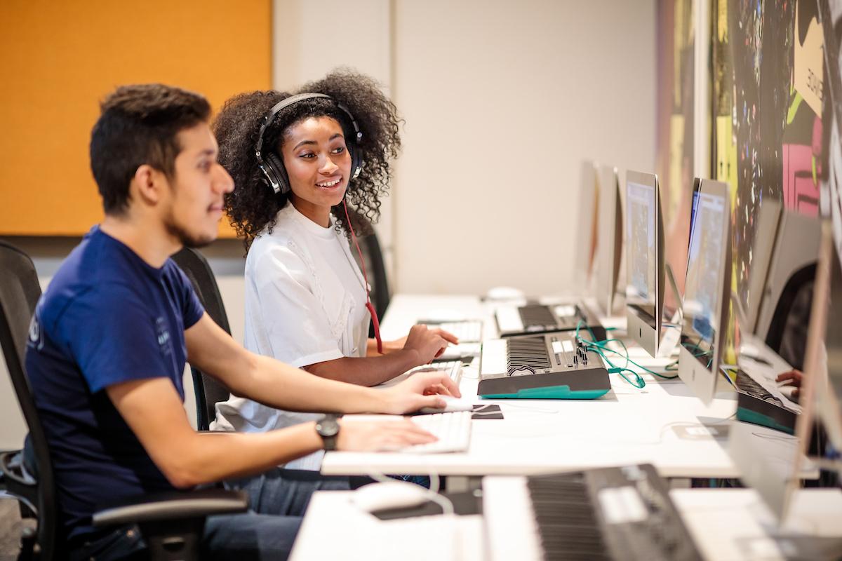 学生 studying together at a computer lab.