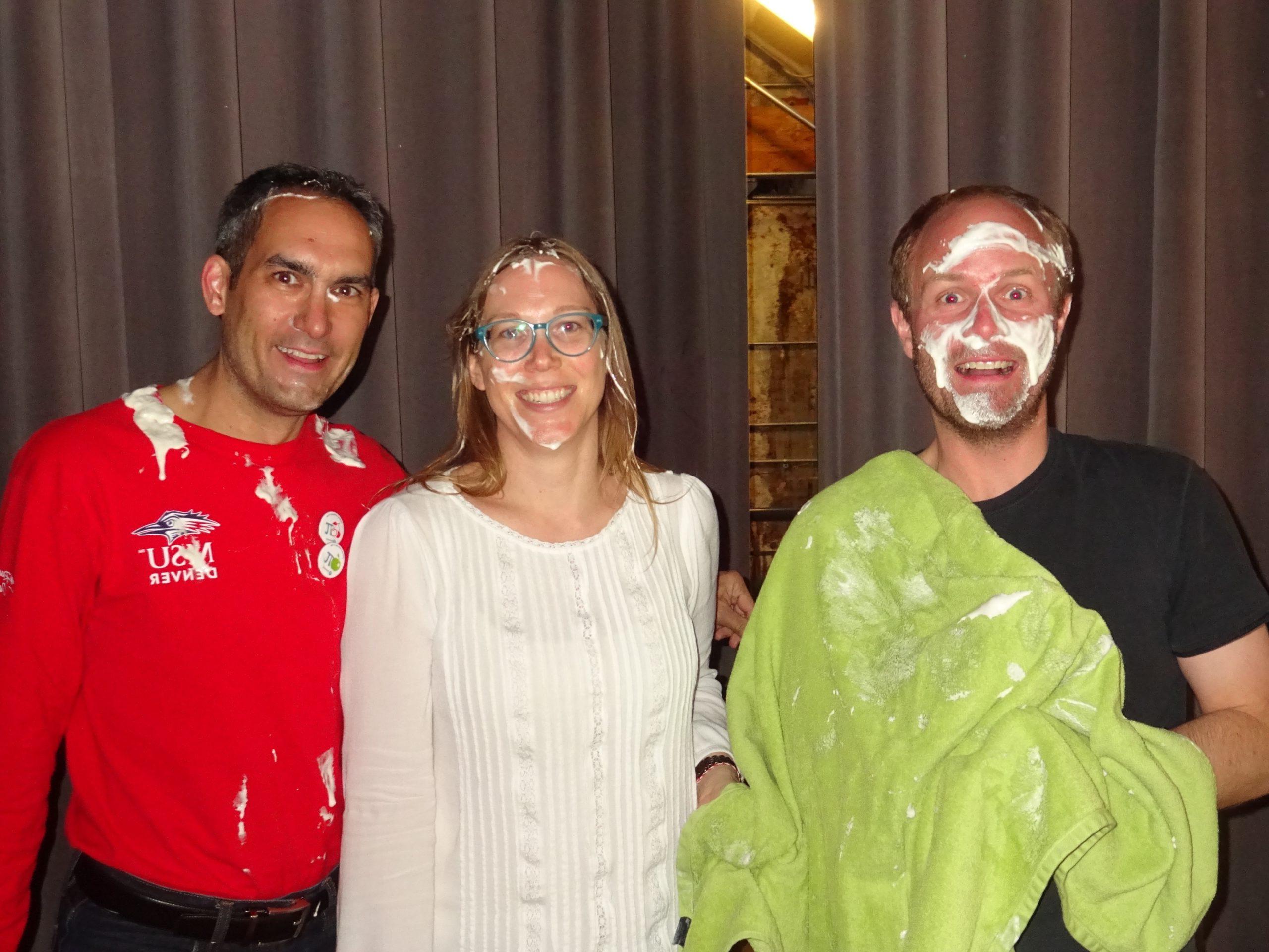 Teachers posing with whipped cream on their faces after being smushed with pies during 