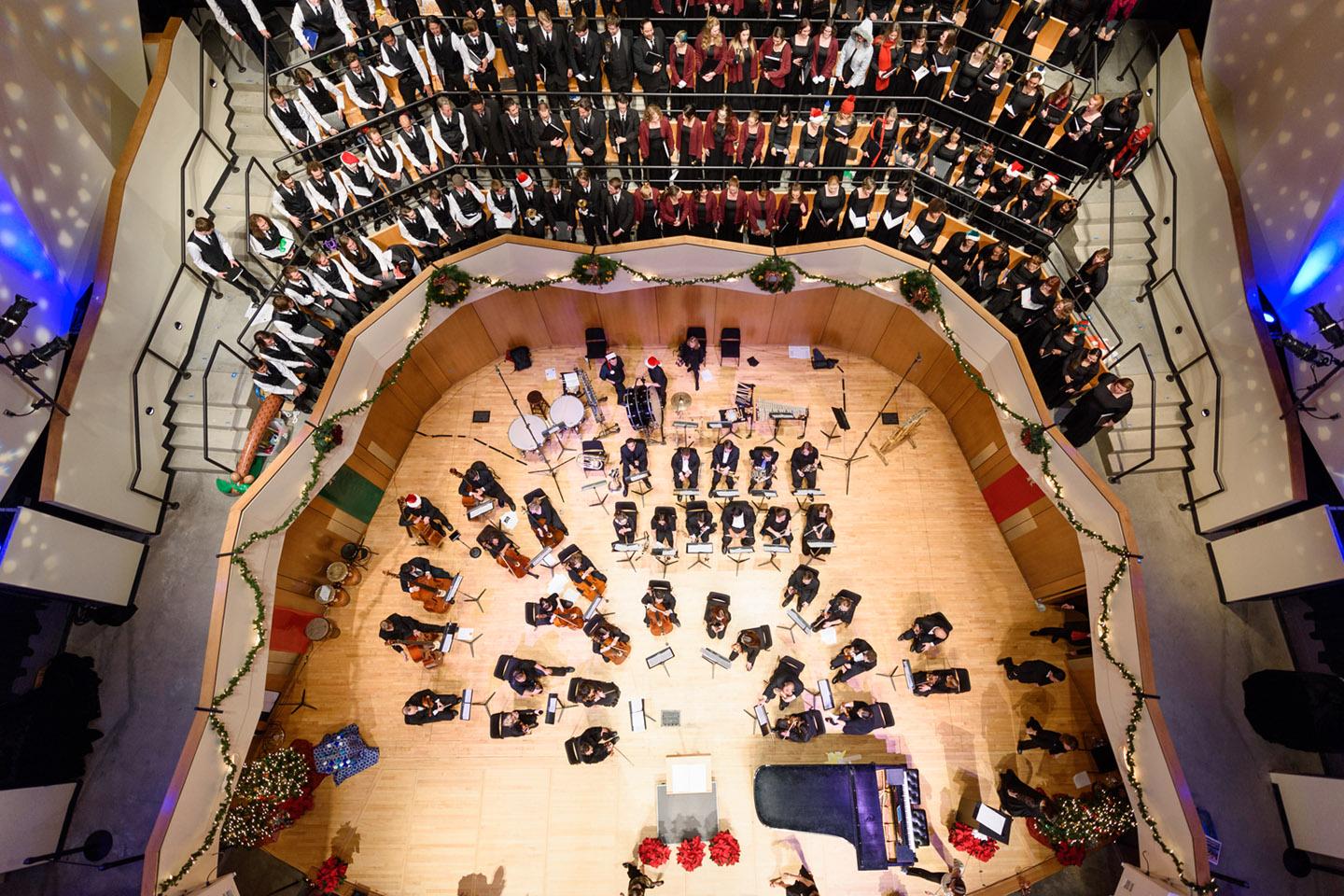 Overhead view of a full orchestra and choir performing in a concert hall