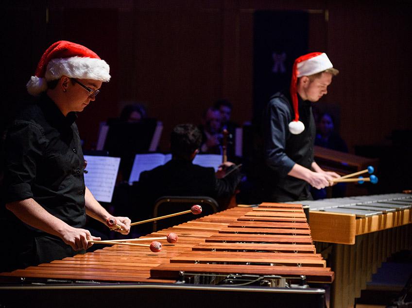 Two marimba players in Santa hats performing