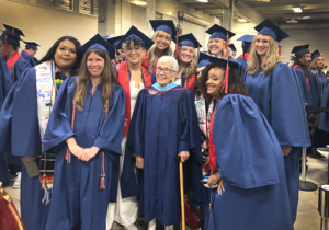 Photograph of Anna Jo Garcia Haynes posing in regalia with Early Childhood Education graduates backstage at the Spring 2023 commencement ceremony.